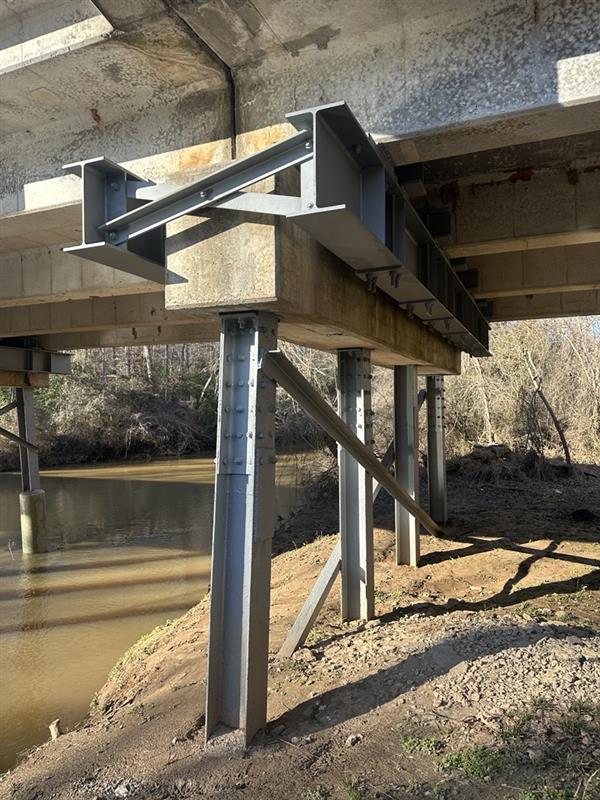 Underneath a bridge with steel support beams and a river below