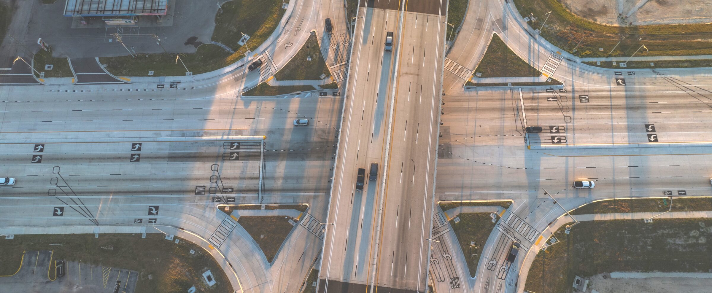 Aerial view of a multi-lane highway intersection with cars and directional markings