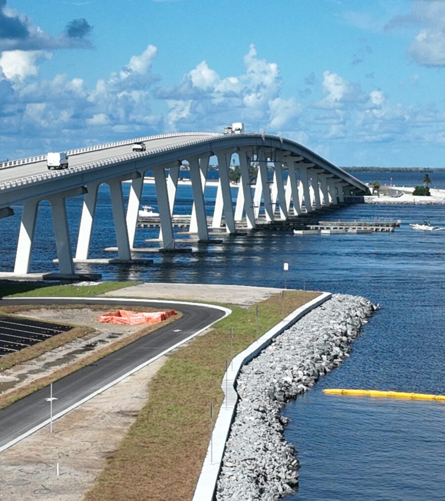 Bridge over wide blue water with vehicles and boats