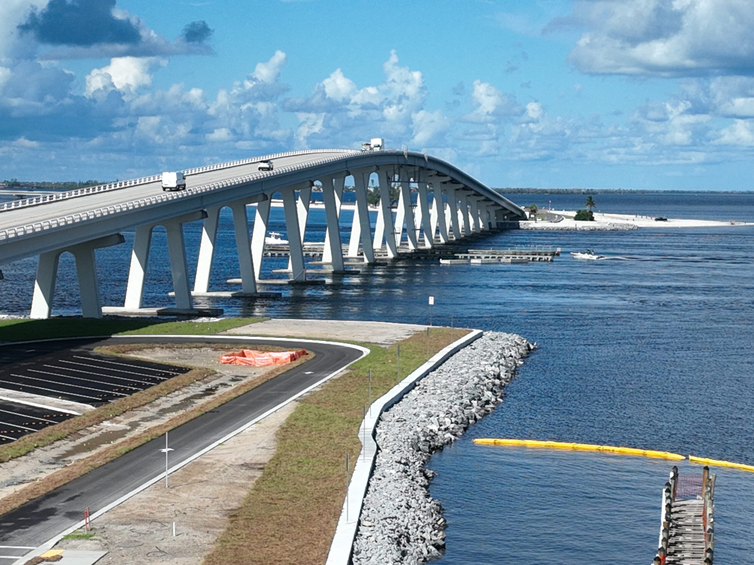 Bridge over wide blue water with vehicles and boats