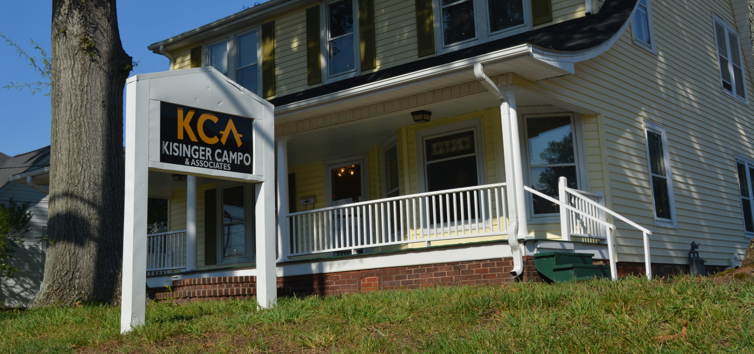 Kisinger Campo & Associates sign outside a yellow two-story house
