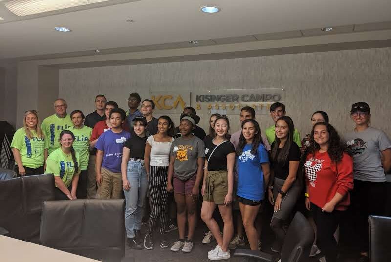 Group of diverse young people in a conference room, with some wearing FLIP t-shirts