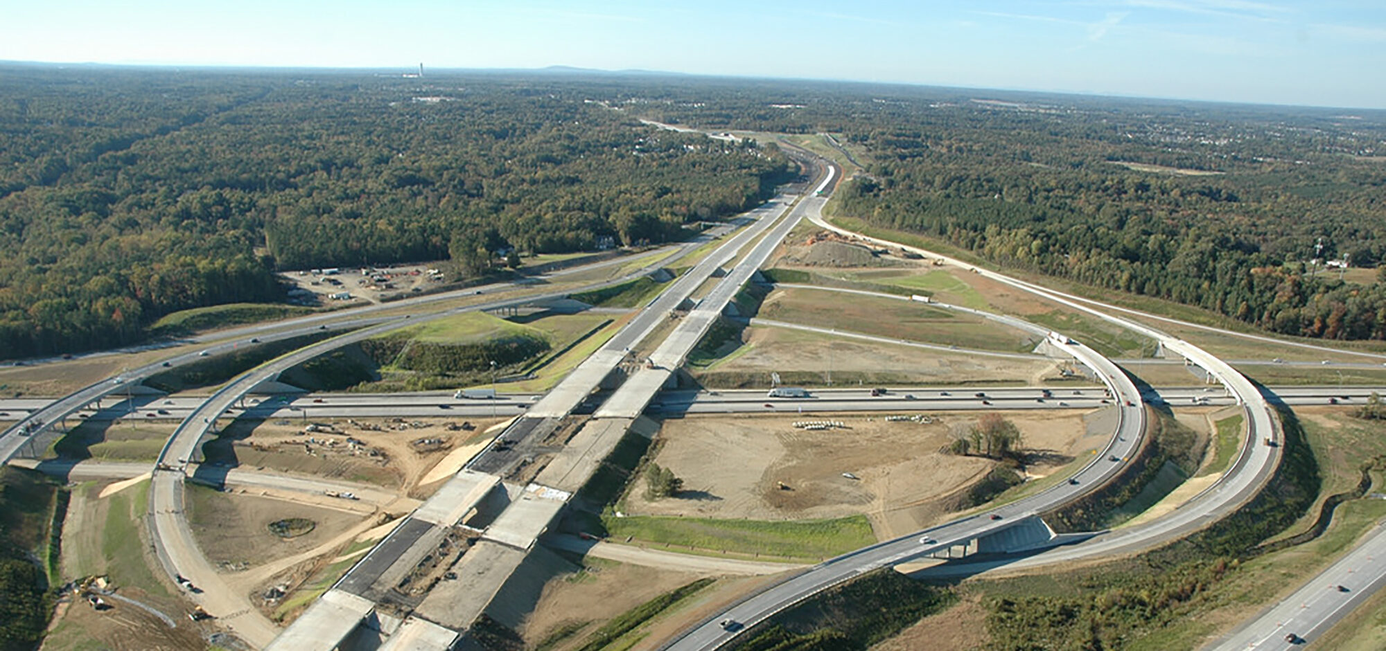 Aerial view of highway interchange under construction with multiple overpasses