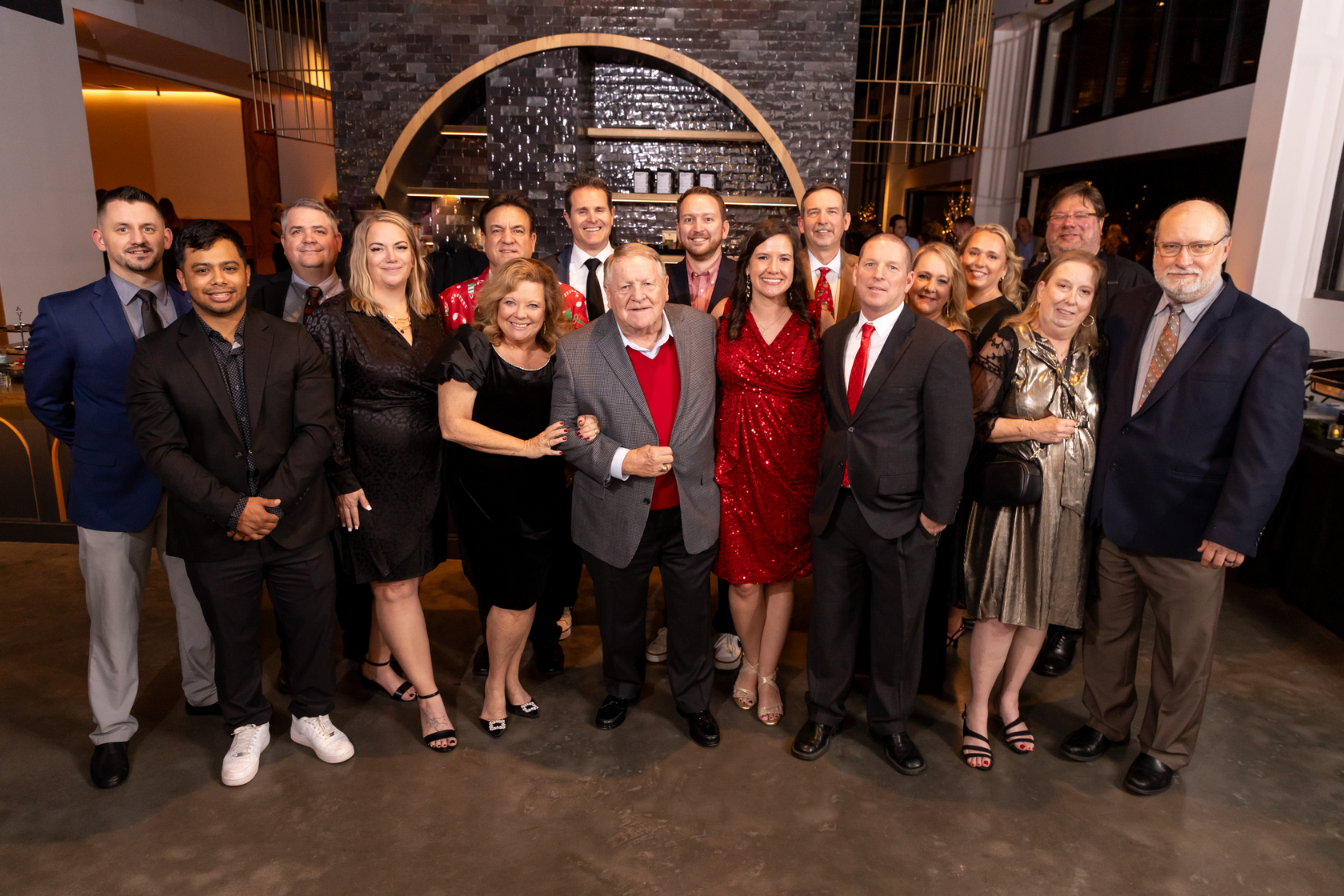 Group photo of people dressed in formal attire at a holiday event
