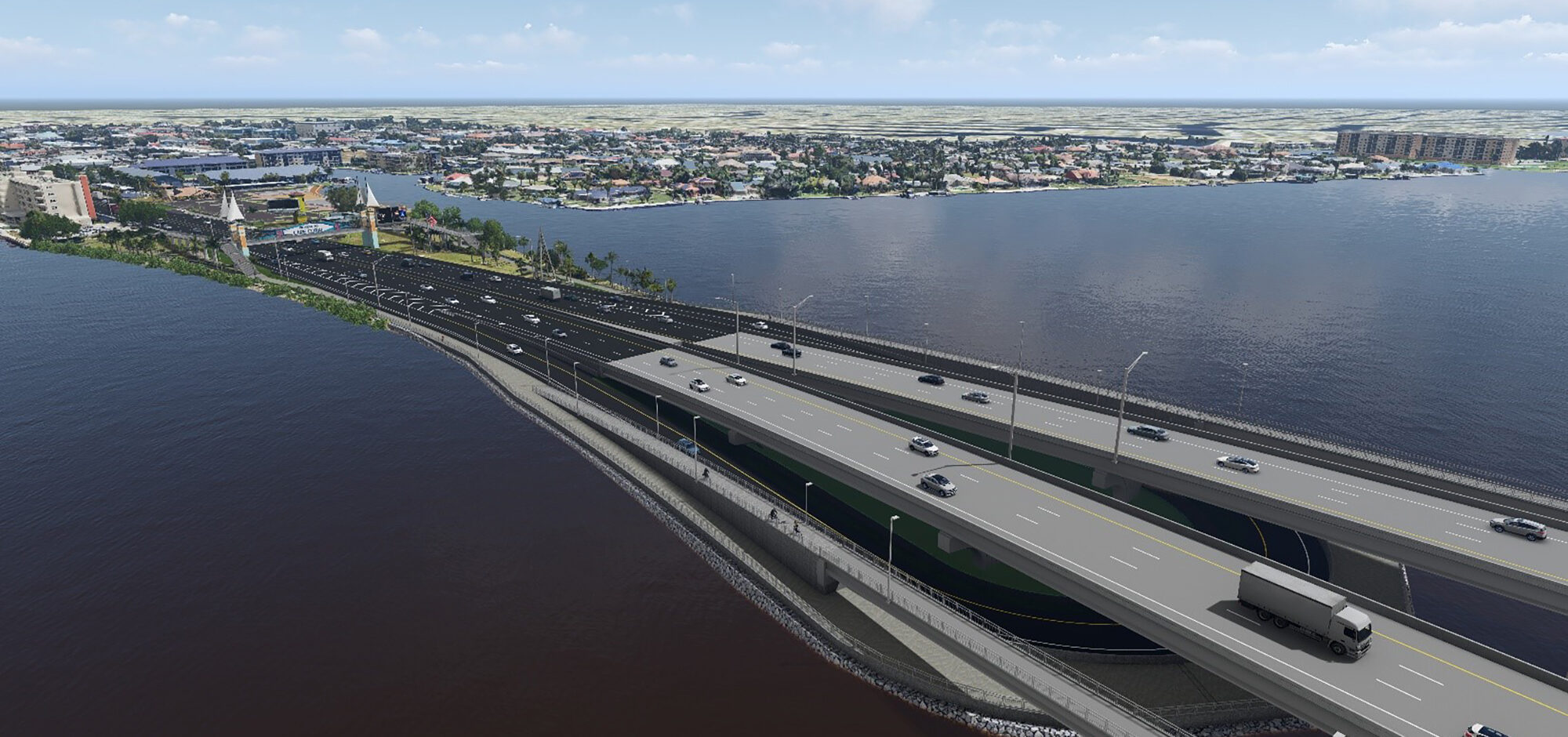 Aerial view of a multi-lane bridge crossing a wide river, with cityscape background and scattered vehicles on the road