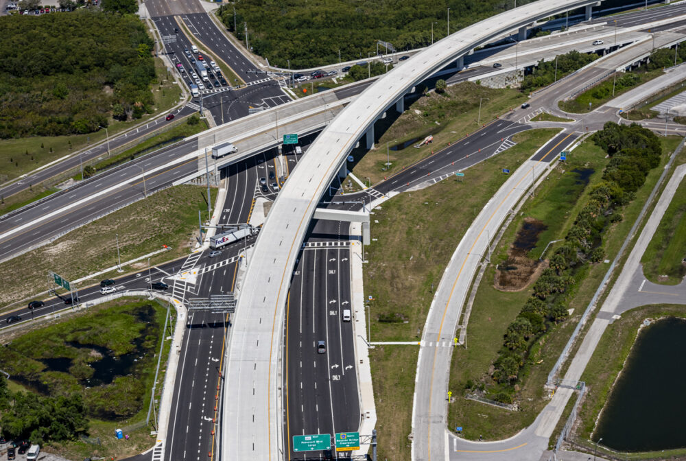 Aerial view of highway interchange with multiple lanes and overpass in urban area