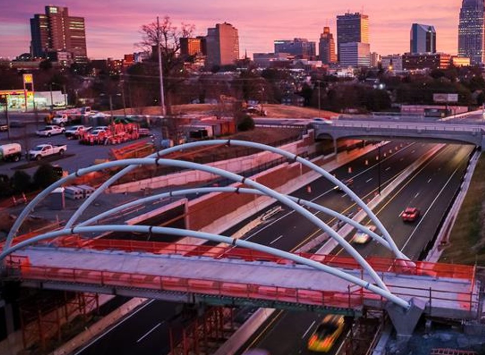 Cityscape at sunset with Salem Parkway bridge, illuminated buildings in background