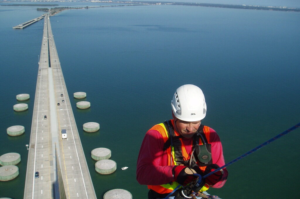Person wearing safety gear rappelling above long bridge over water, dated 12/5/2008