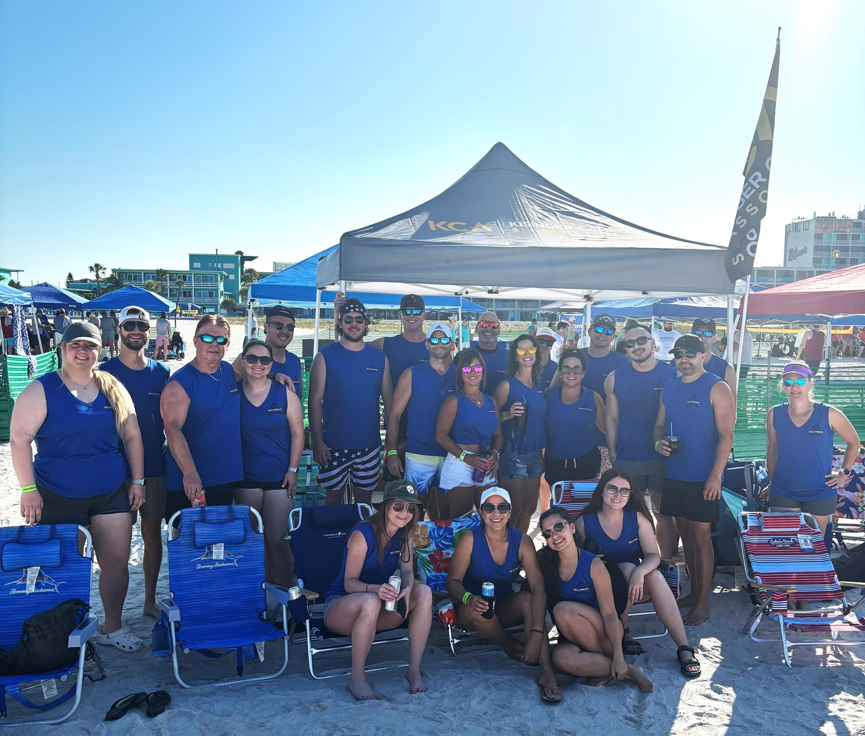 Team-Photo-42024.jpg shows a group in blue shirts at a sunny beach event under a KCA tent