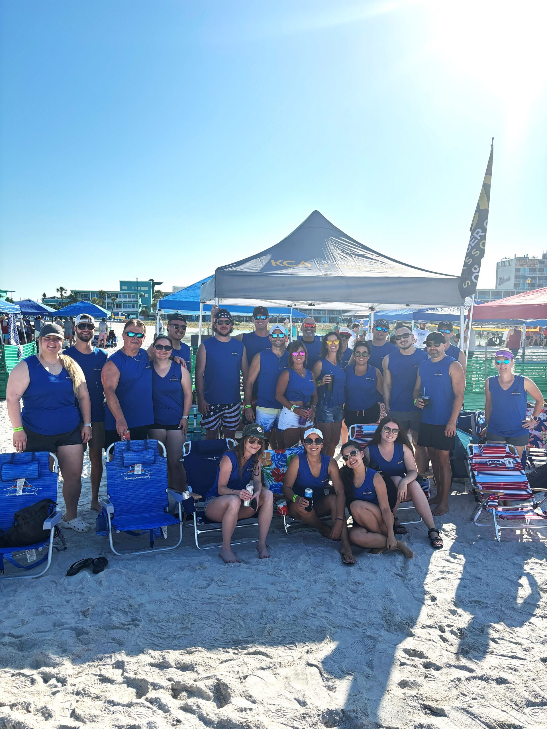 Team-Photo-42024.jpg shows a group in blue shirts at a sunny beach event under a KCA tent