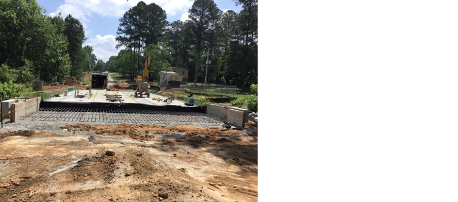Construction site for a bridge across a rural road, machinery, and trees