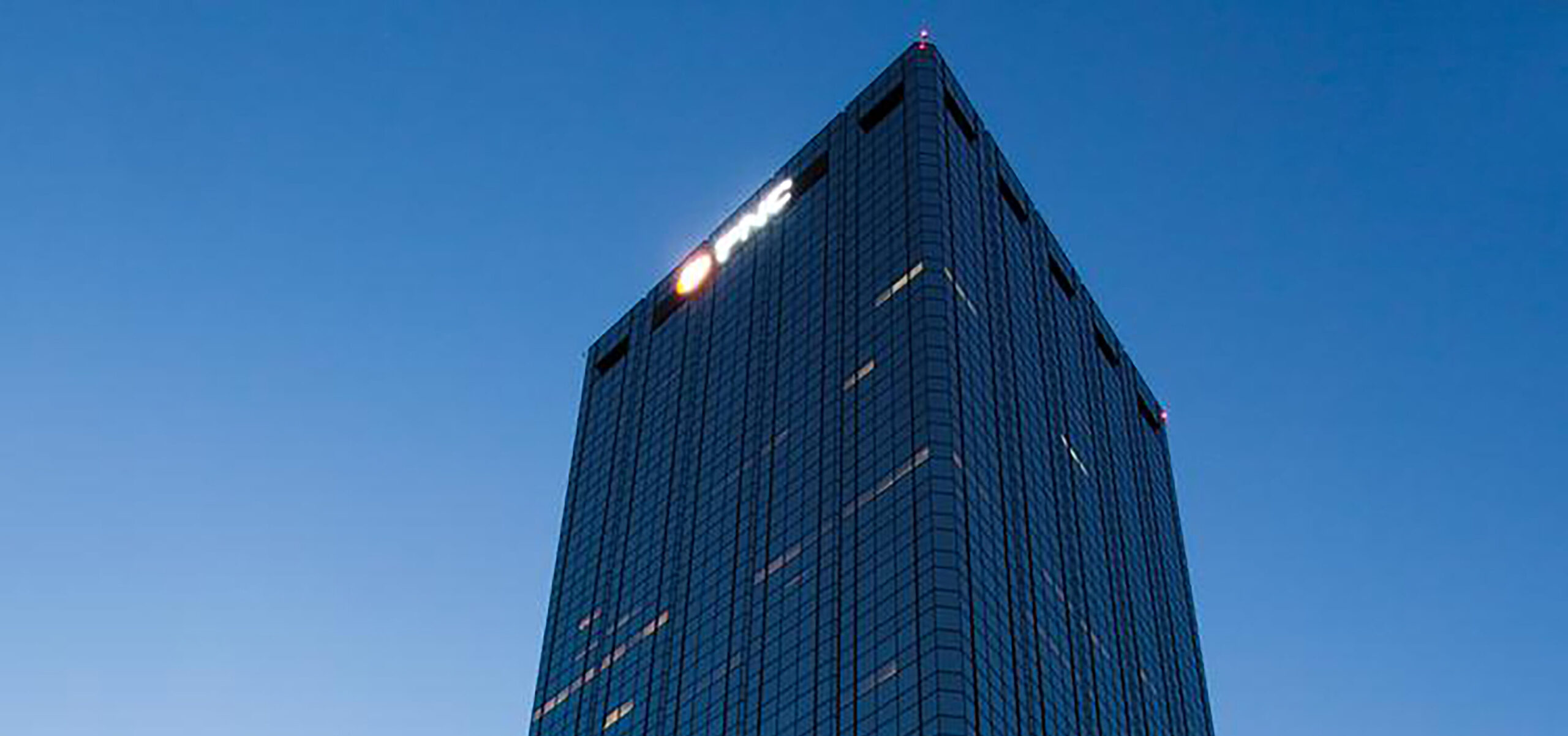 Tall glass skyscraper under evening sky, with PNC logo