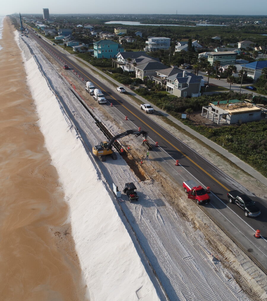 Aerial view of beachside road construction with traffic control measures