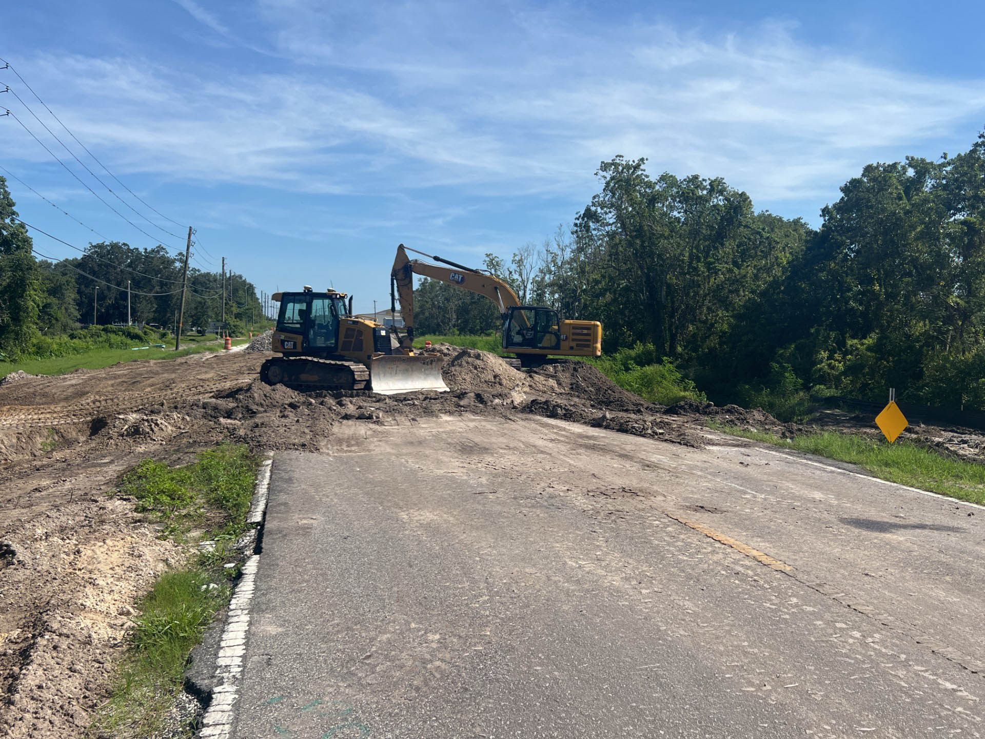 Excavation site with a backhoe and bulldozer clearing earth on a sunny day