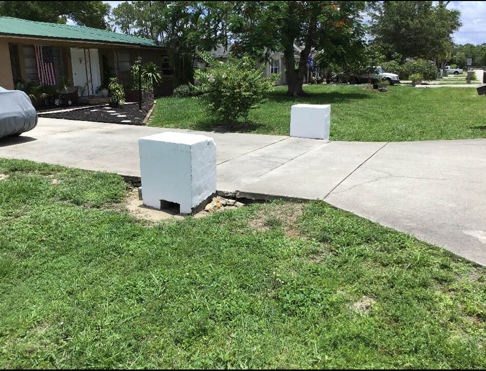 White concrete barriers on driveway entrance in suburban neighborhood