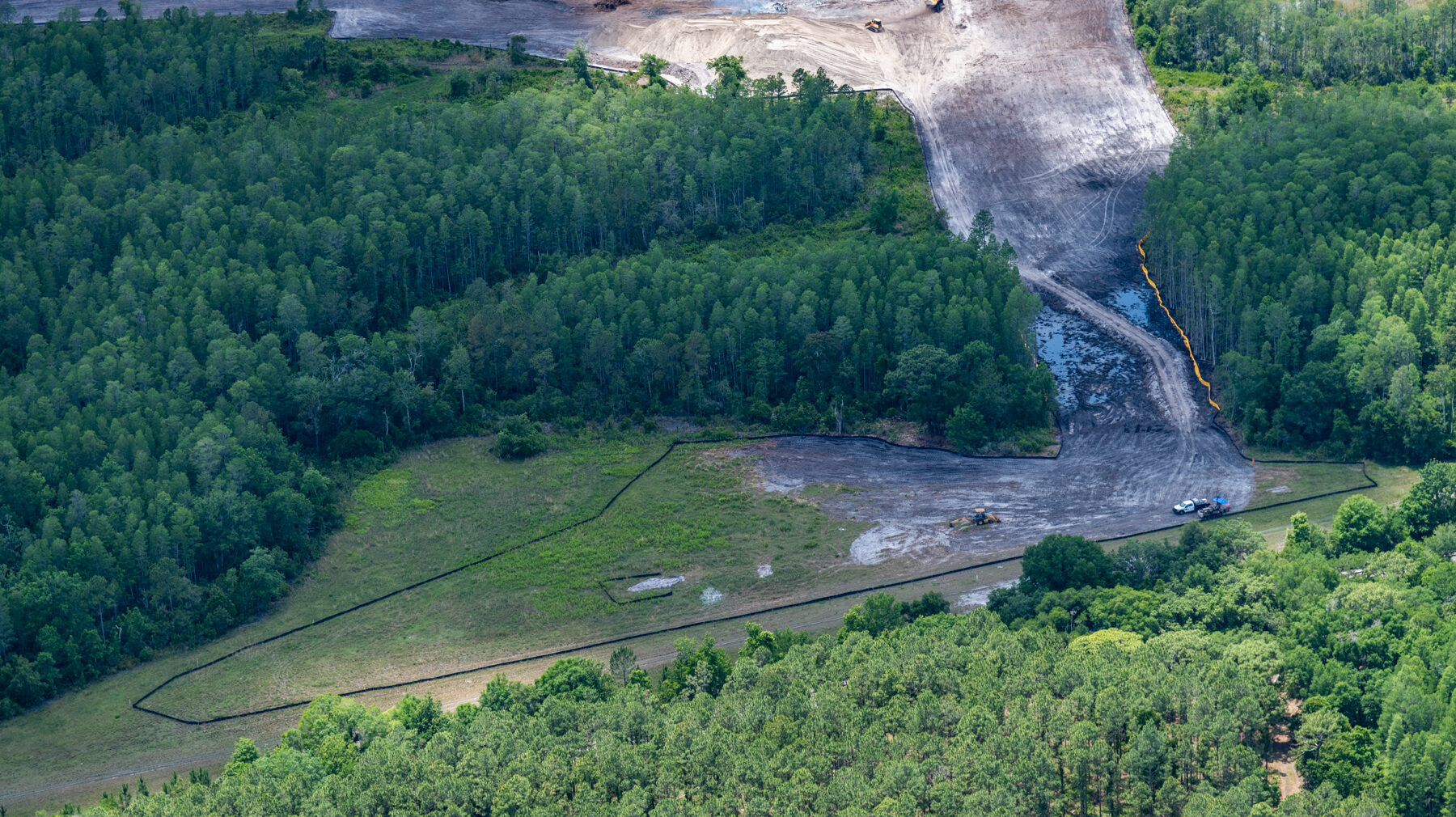 Aerial view of Ridge Road Extension Phase 2B construction site surrounded by dense forest