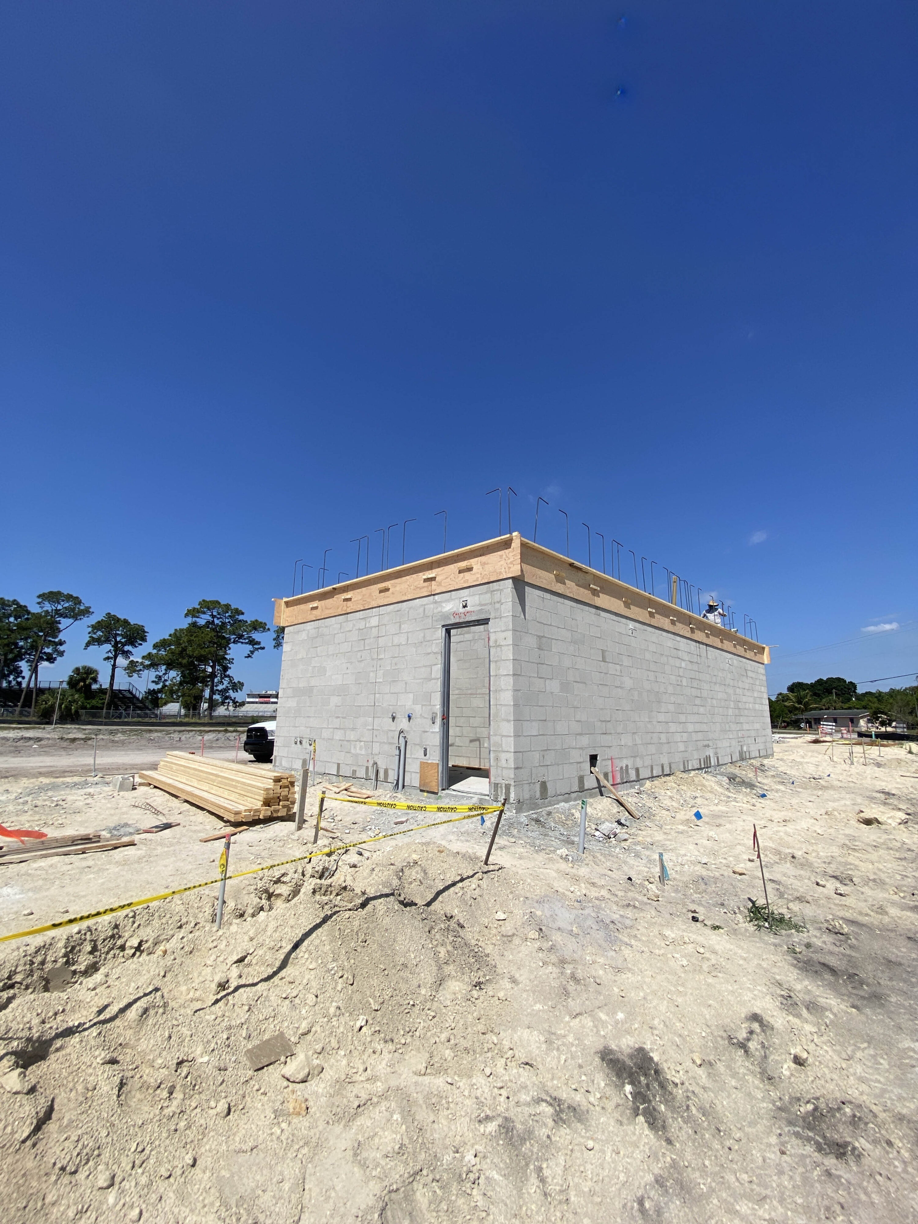 Construction site showing a partially built concrete structure under clear blue sky
