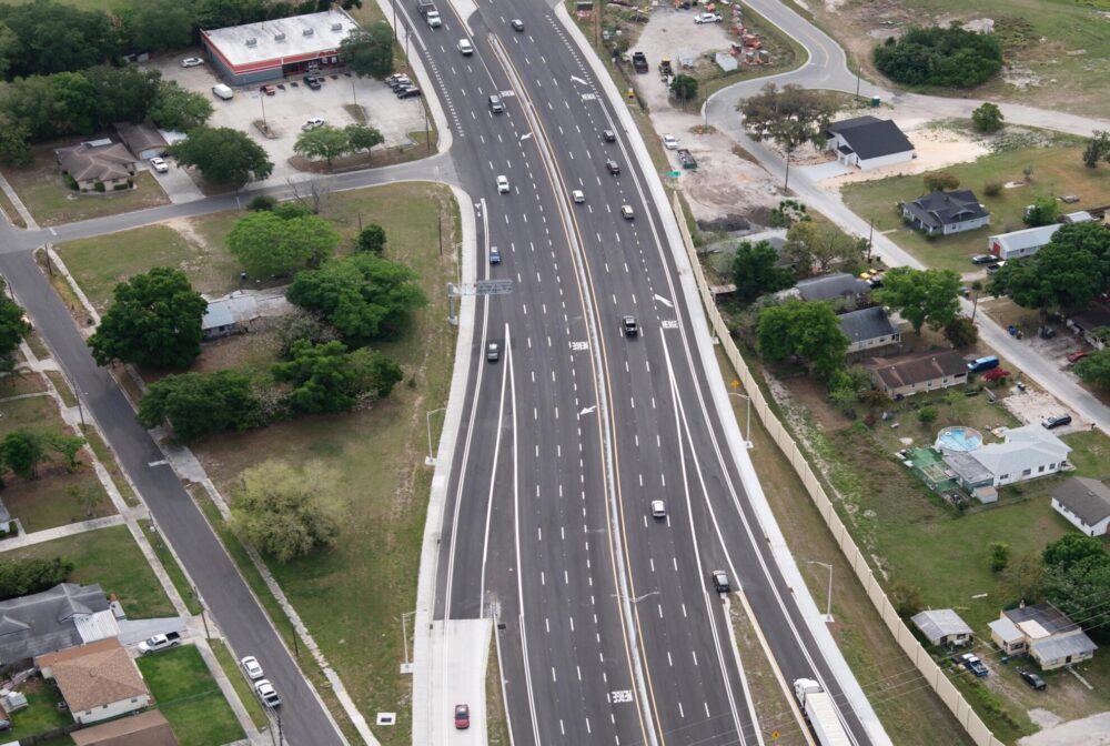 Aerial view of US27-SR60 interchange, multiple lanes, surrounding residential area and greenery