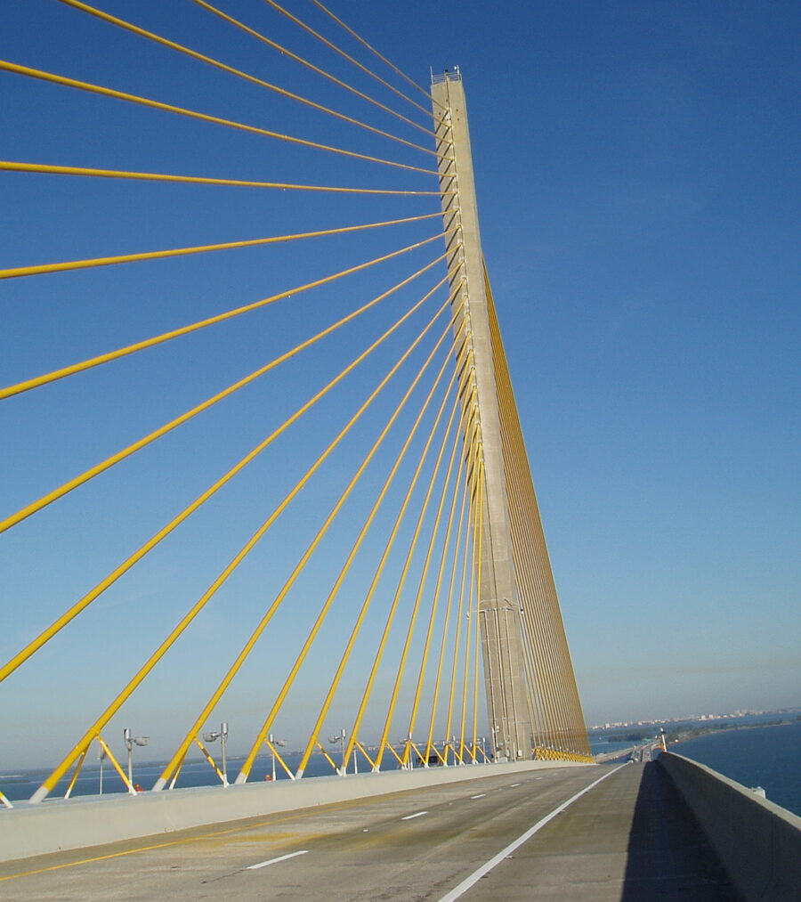 Tall cable-stayed bridge with yellow cables against a clear blue sky