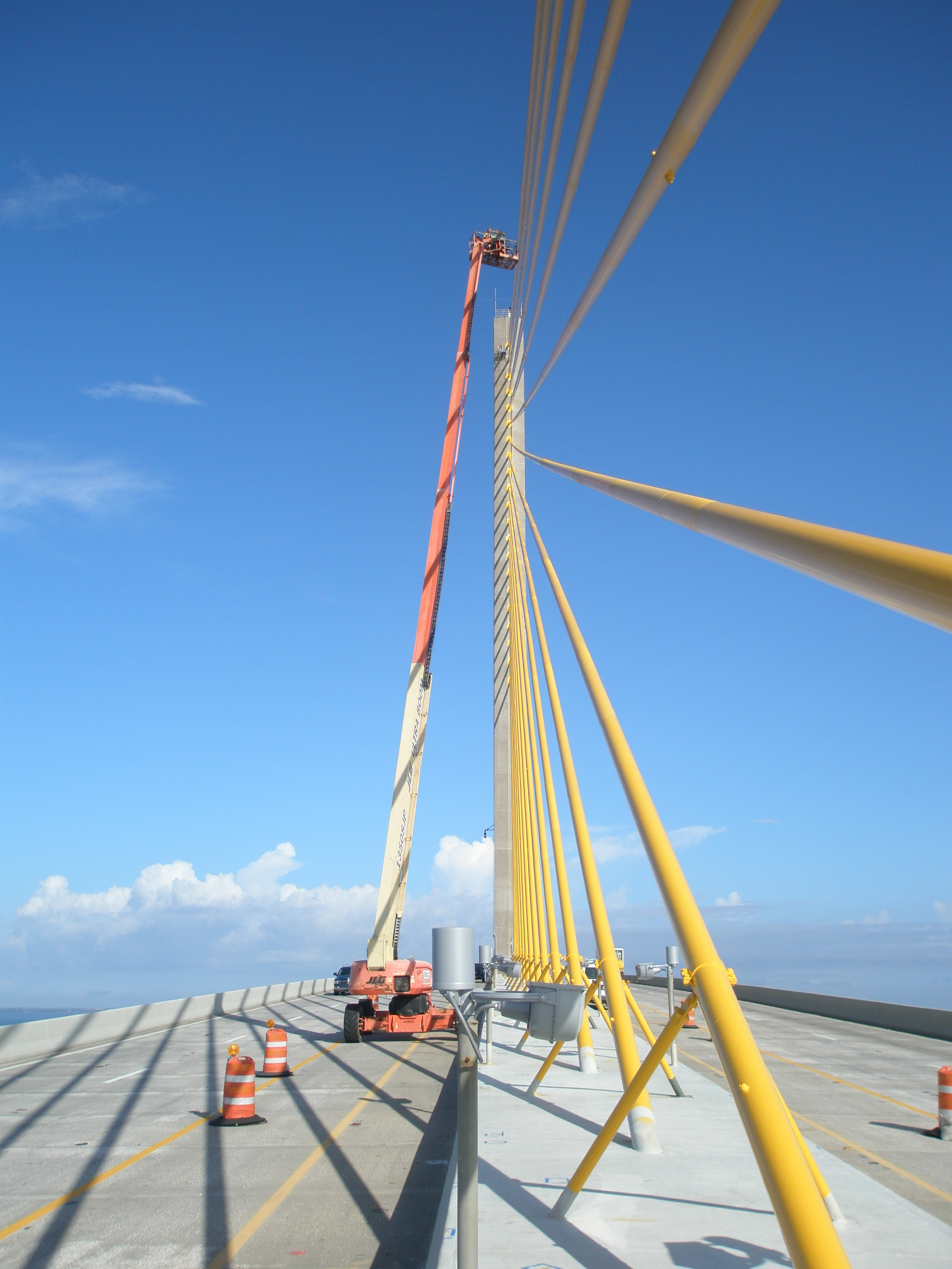 Augustine Bridge maintenance, featuring crane lift and orange pylons under clear sky