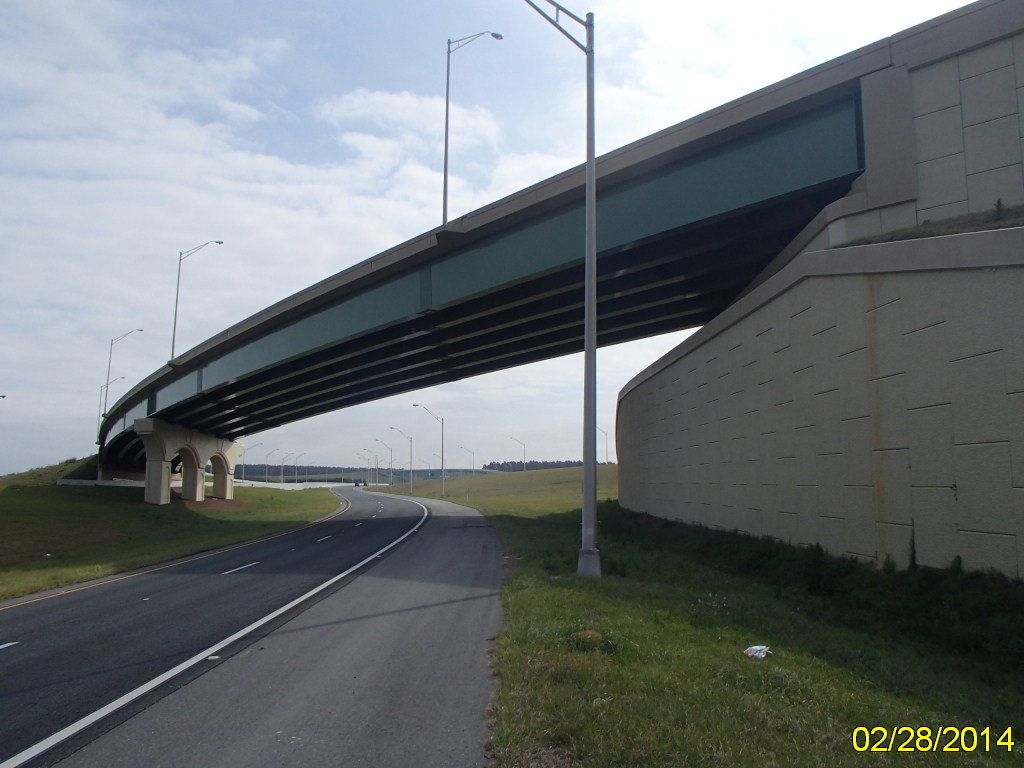 Elevated highway bridge with supporting pillars over a curved road