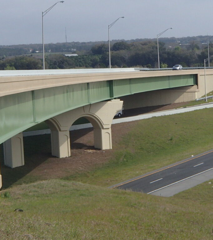 Elevated highway with green supports, overpass, and cars