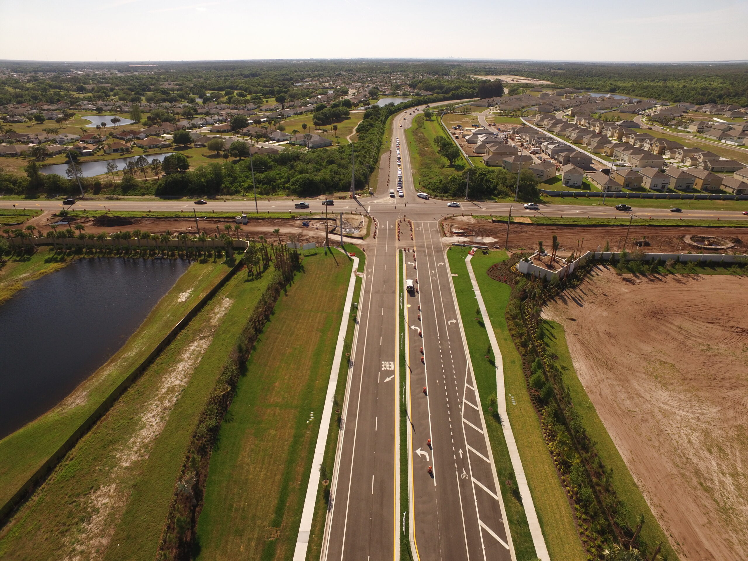 Aerial view of suburban road intersection with surrounding houses and greenery