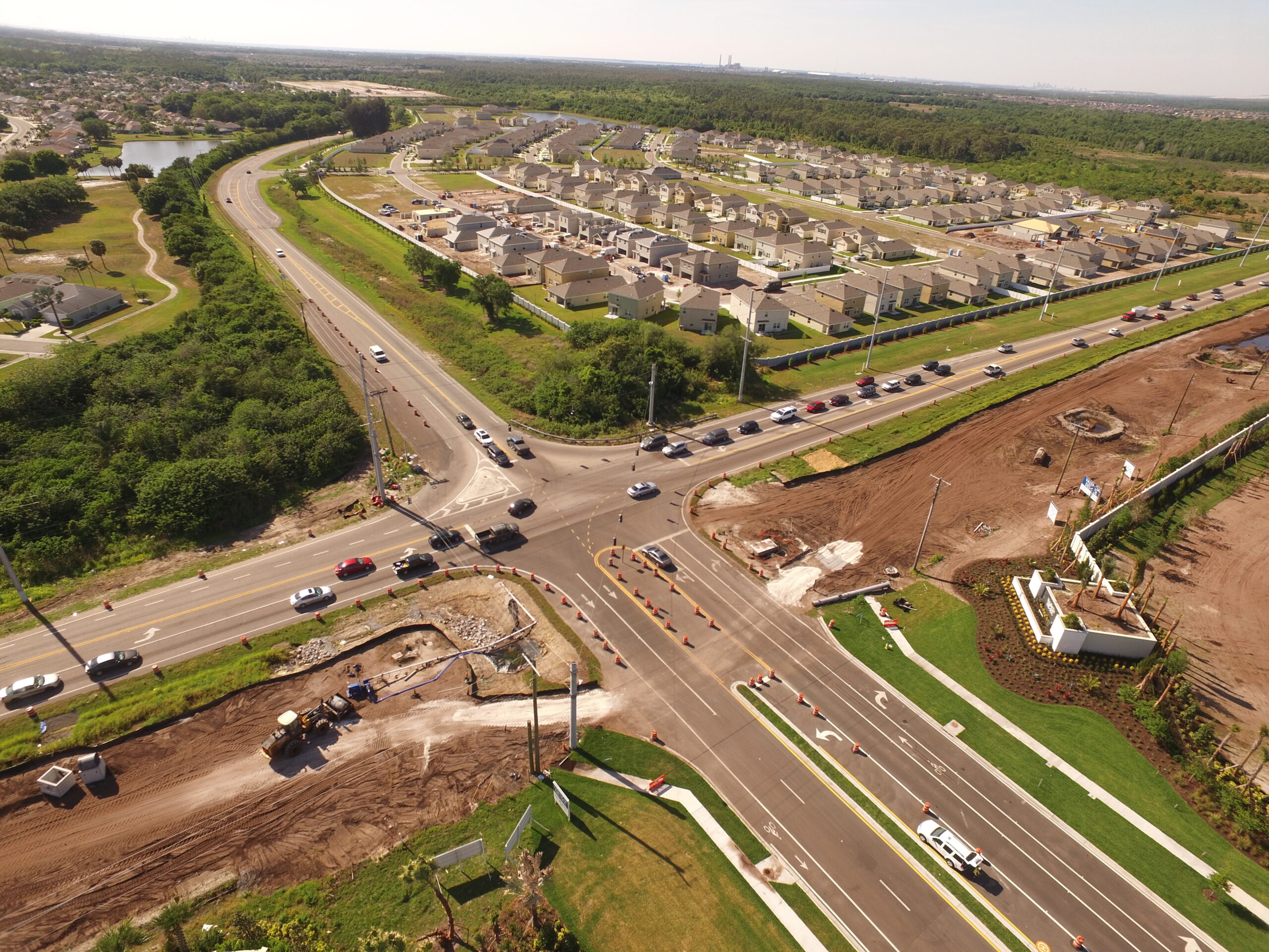 Aerial view of a busy intersection near a suburban neighborhood with ongoing road construction and traffic