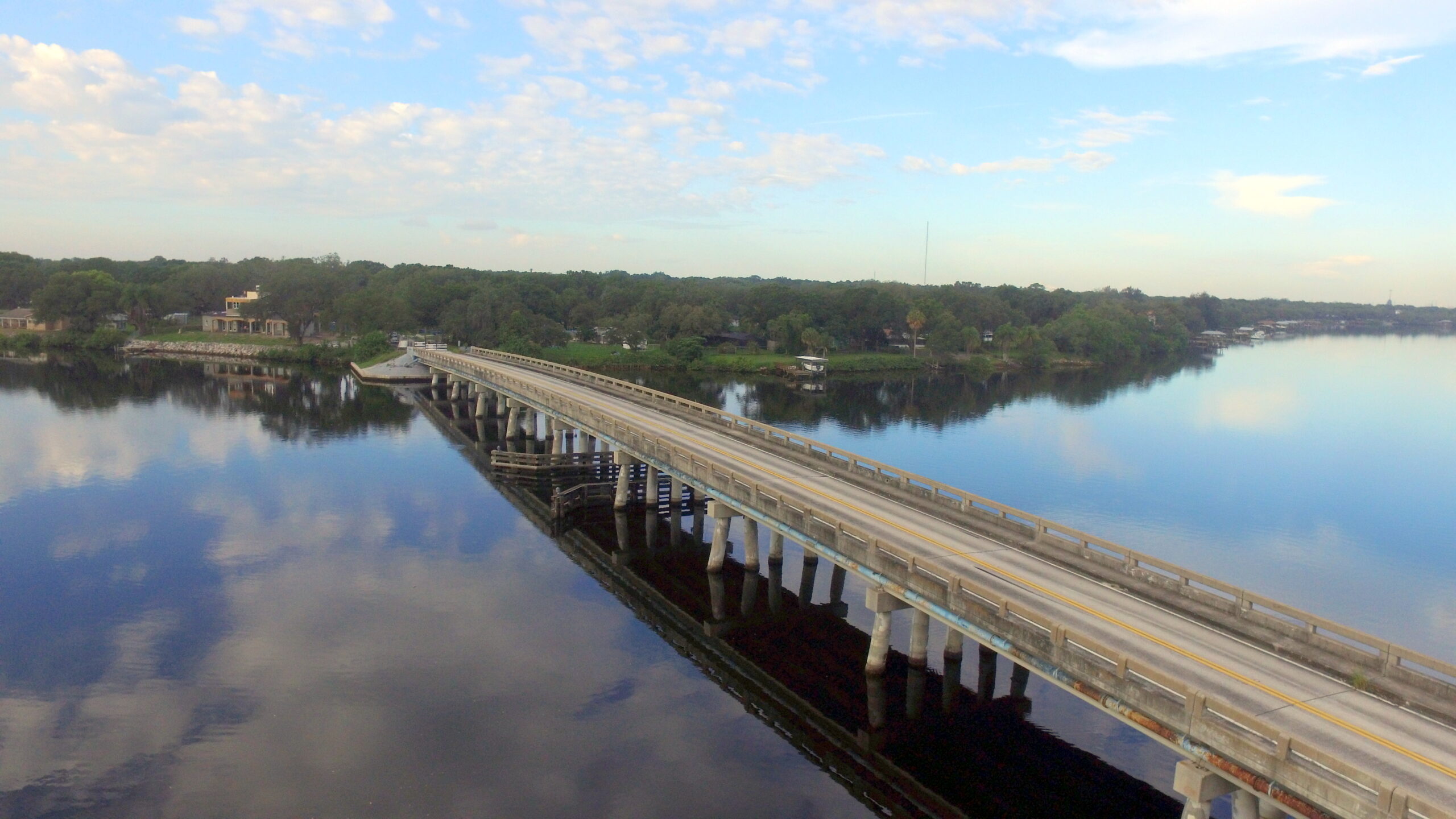 Bridge over calm river with blue sky reflection