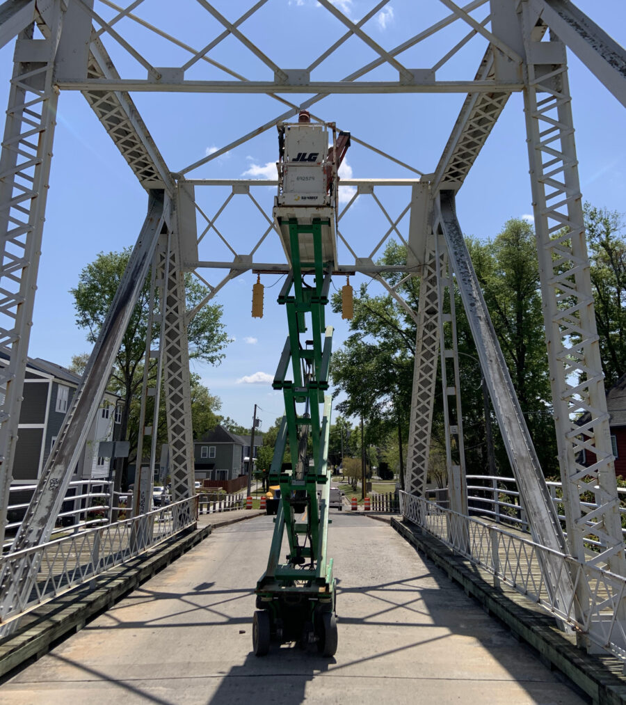 Lift working on a steel bridge, clear sky background