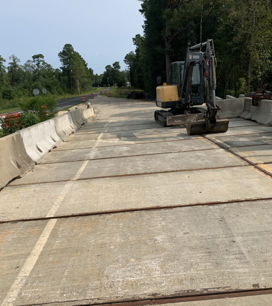 Construction site with an excavator on a concrete road