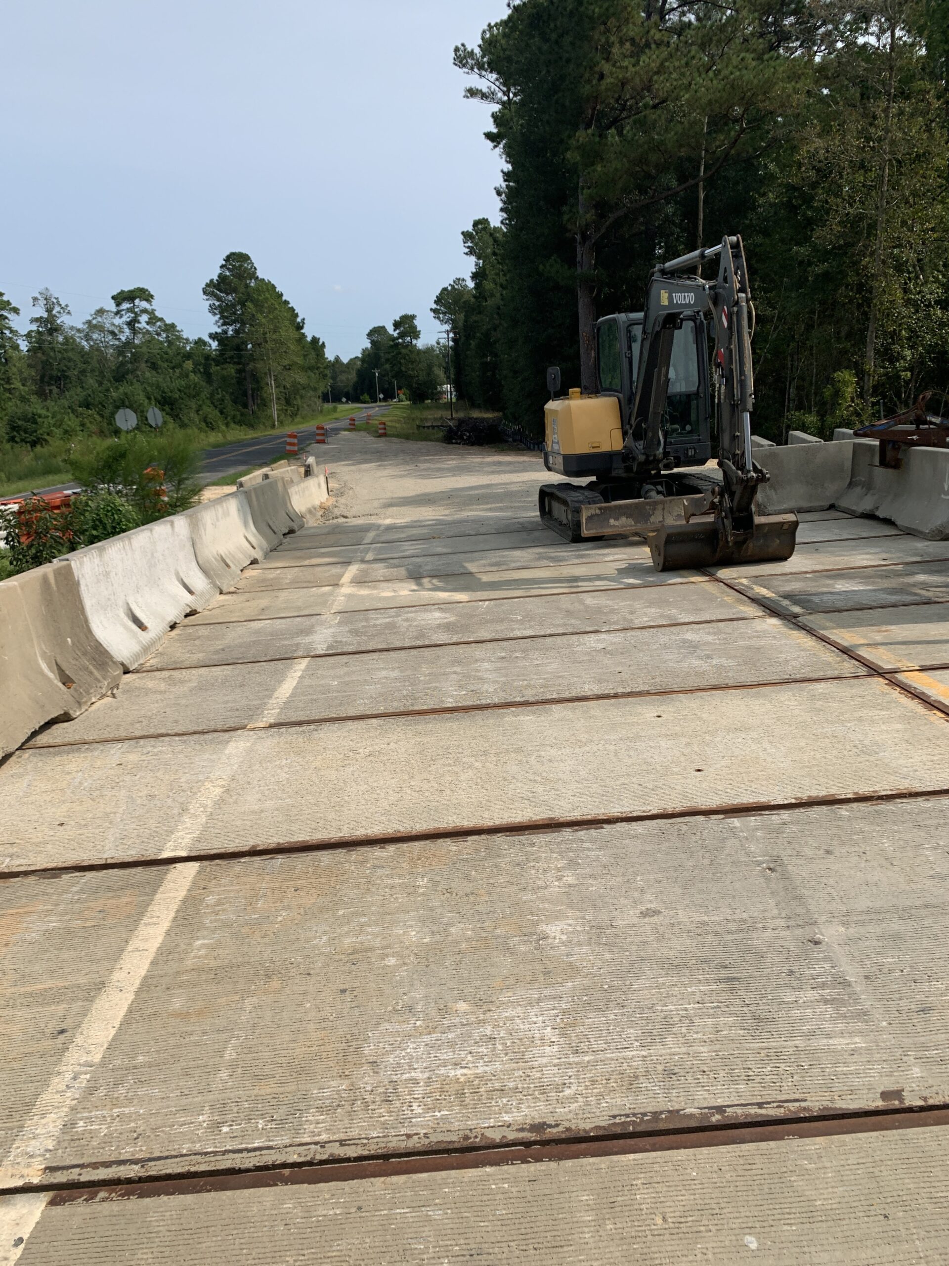 Construction site with an excavator on a concrete road