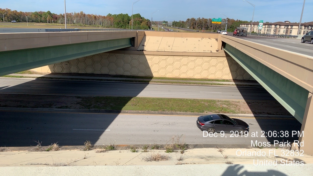 Overhead view of a road underpass with a single car driving; timestamp: Dec 9, 2019, 2:06:38 PM, Moss Park Rd, Orlando, FL 32832, United States
