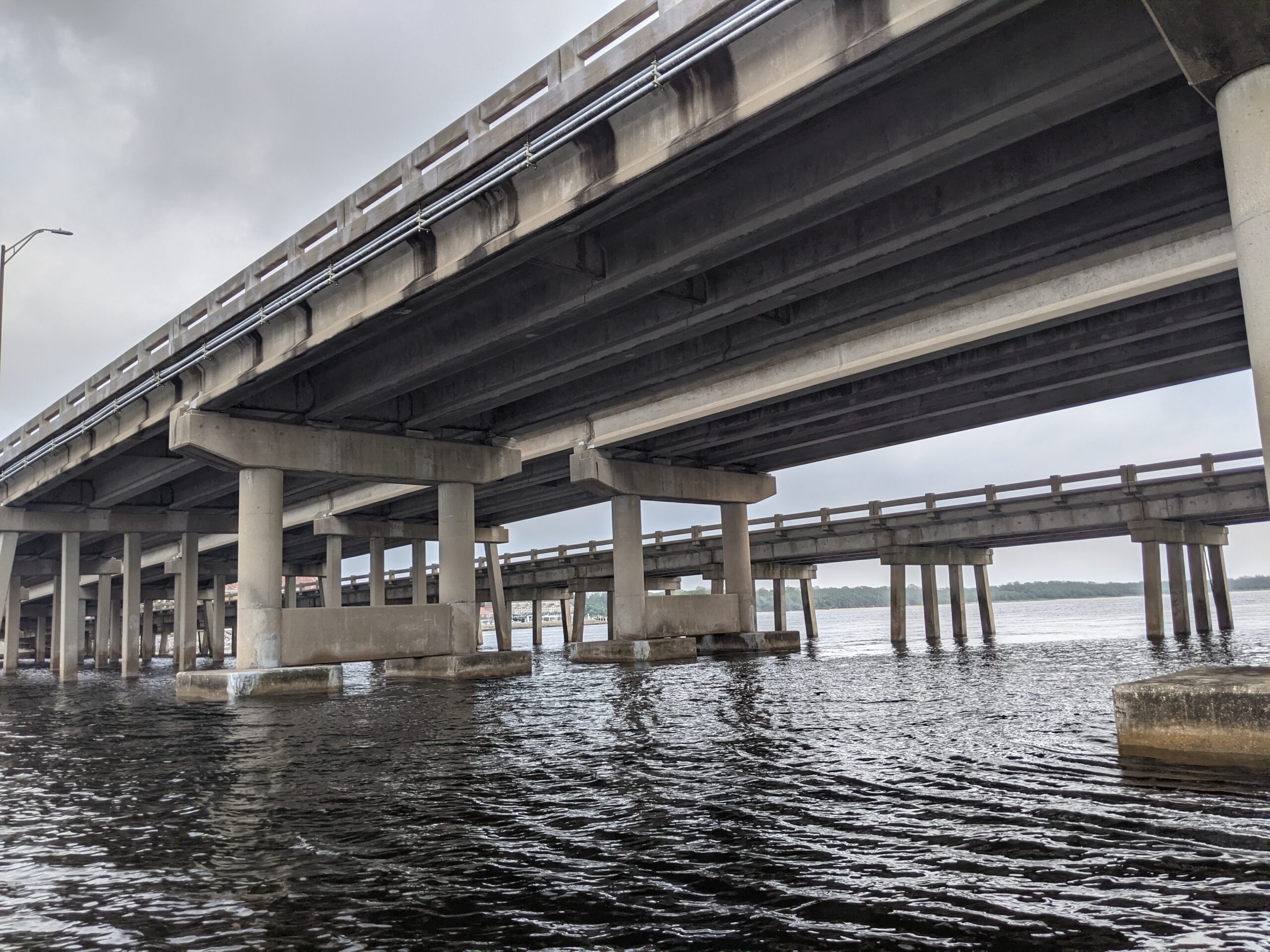 Underneath view of highway bridge over calm water