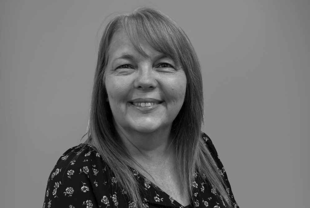 Lori smiling warmly in black and white portrait