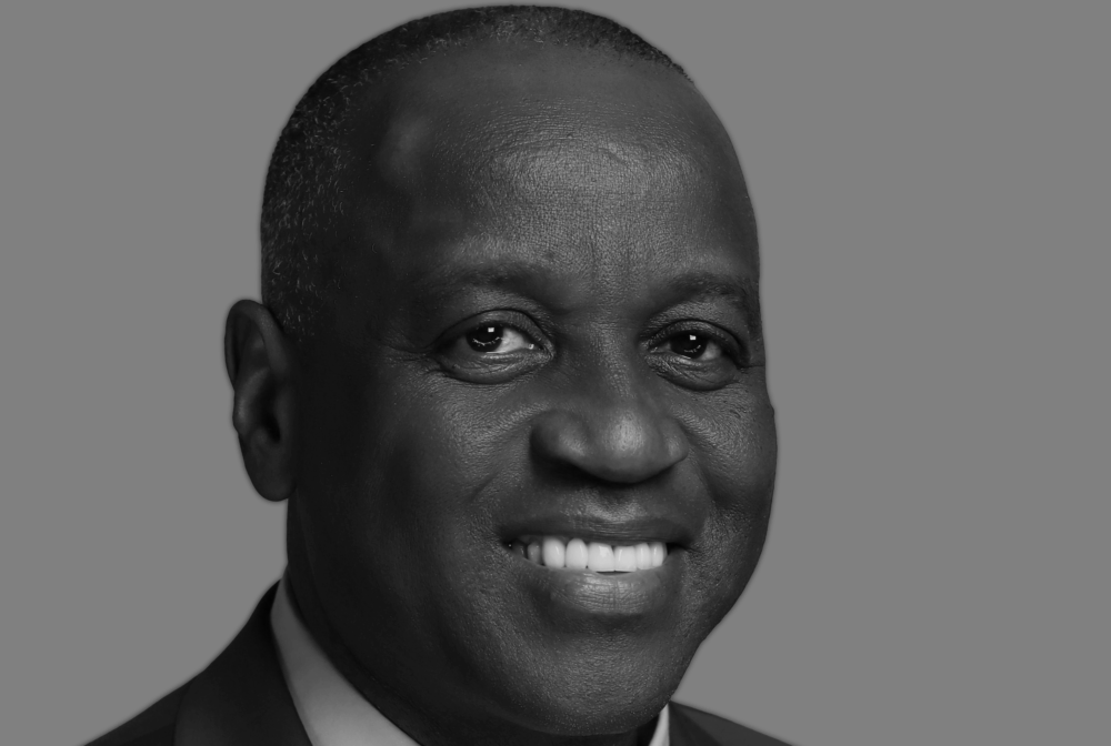Richard smiling in black-and-white portrait with a neutral background