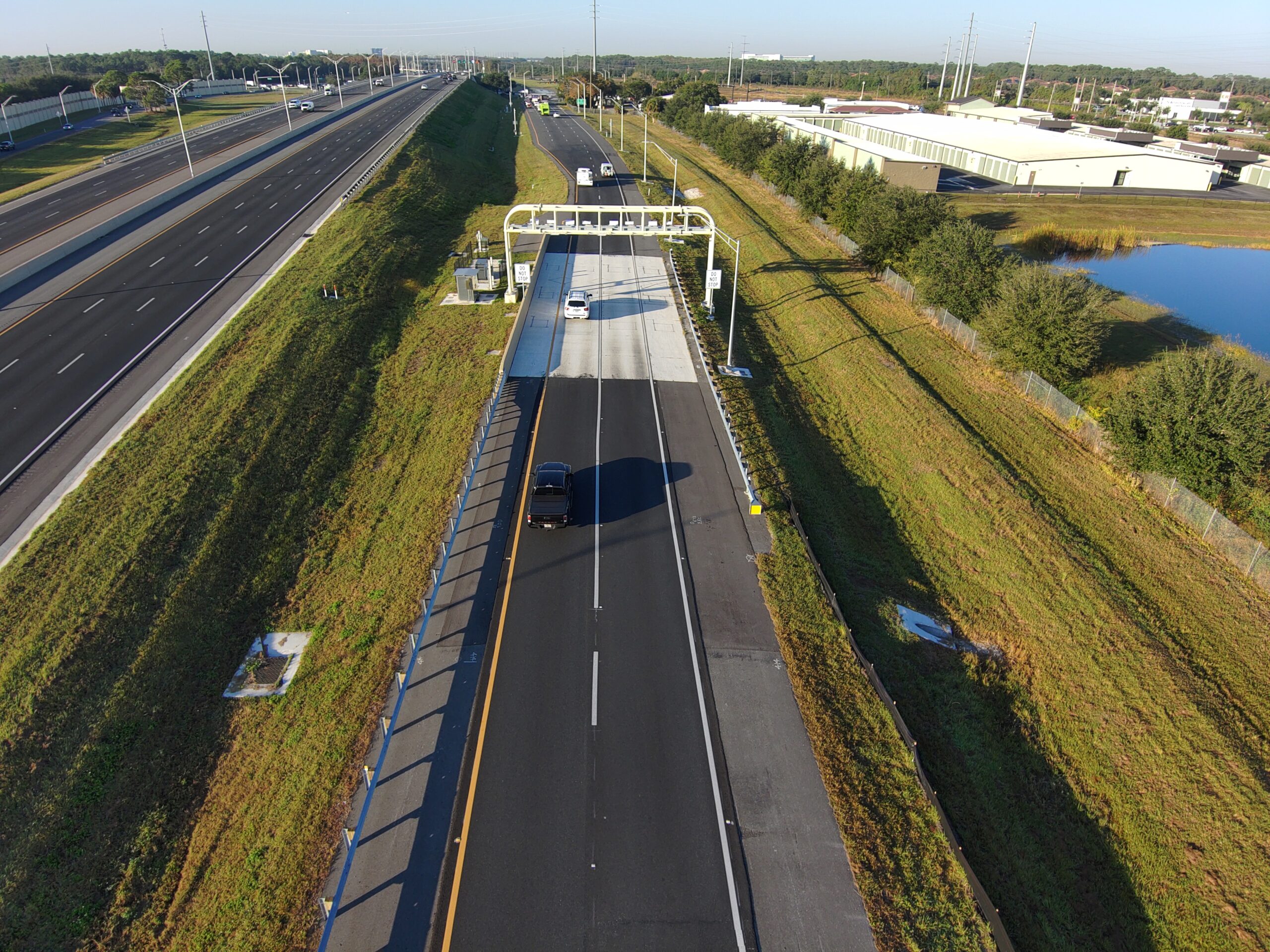 Aerial view of highway with a toll station and two cars
