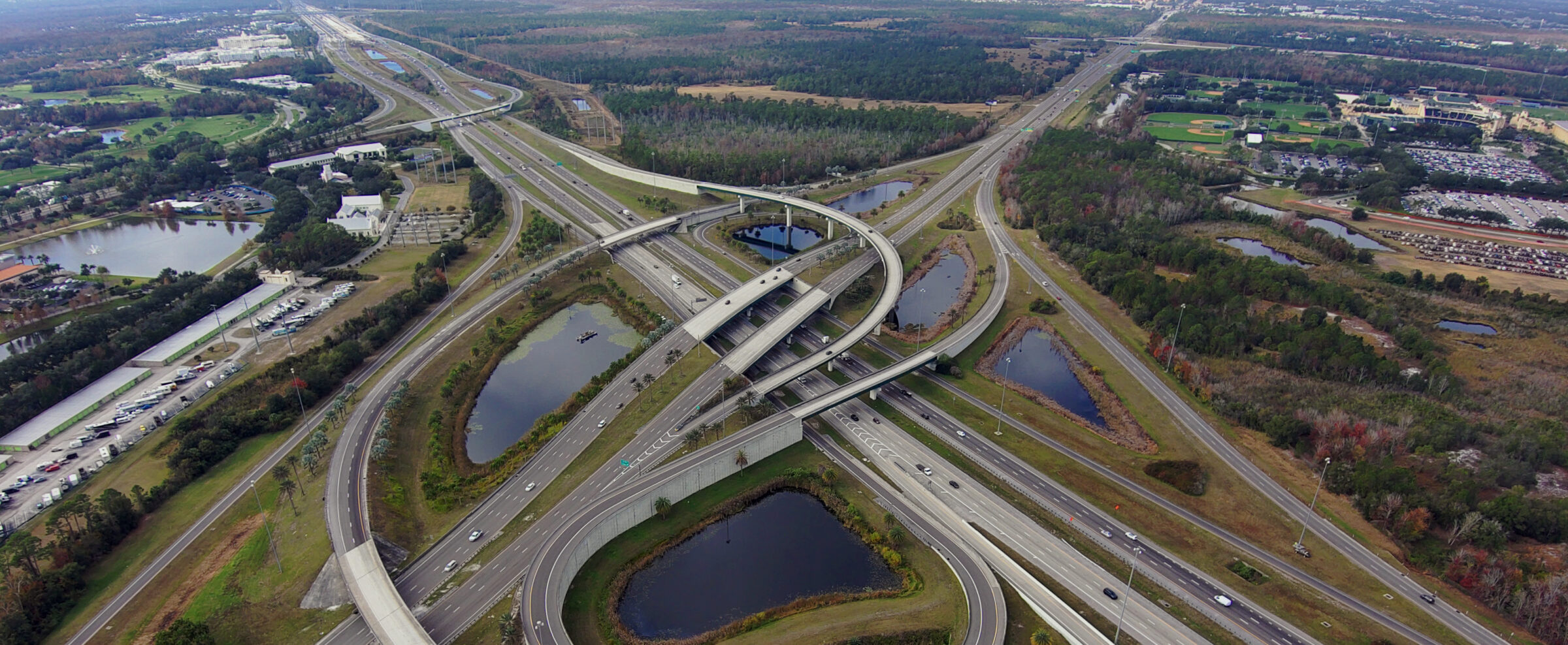 Aerial view of sprawling highway interchange with multiple overpasses and surrounding greenery