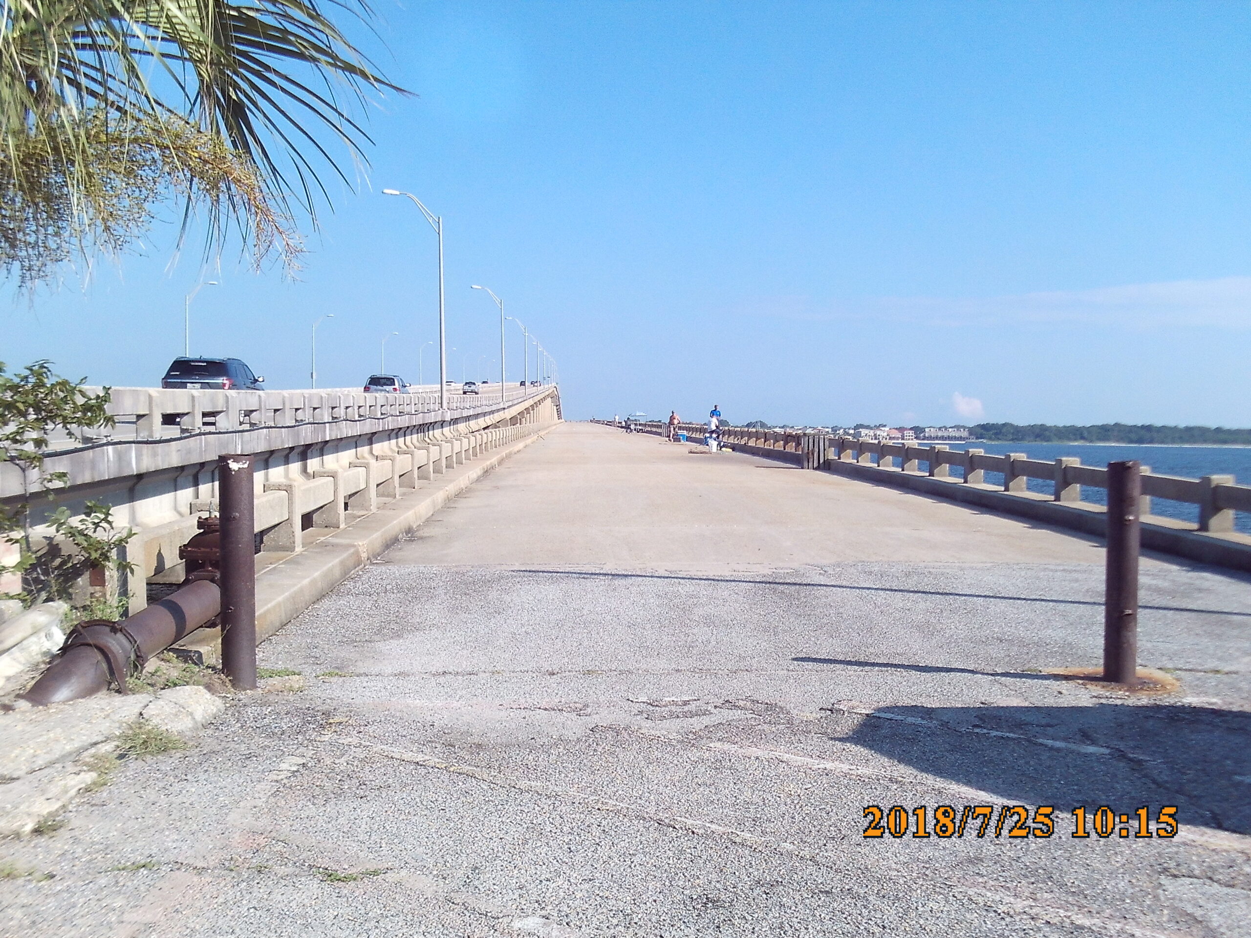 Cars and people on a bridge under a clear blue sky; date stamp 2018/7/25 10:15