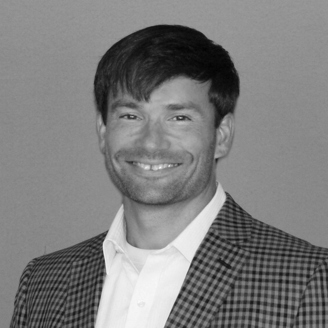 Senerchia-Abe smiling in formal attire against plain background
