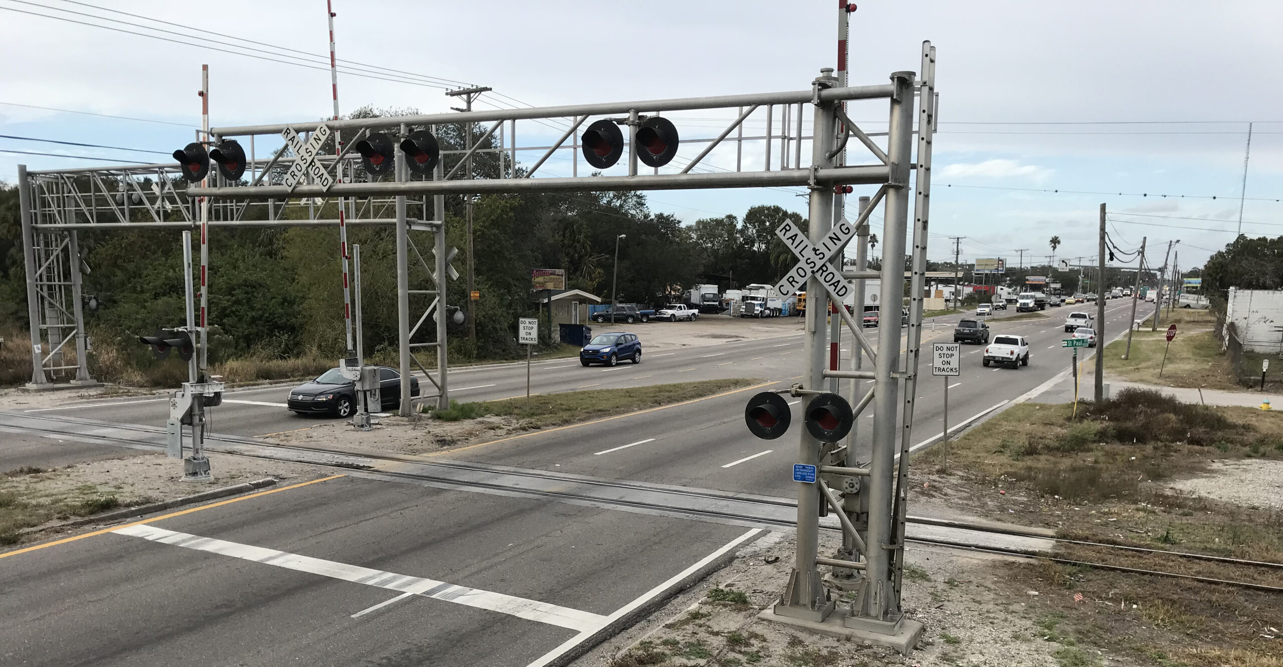 US 41 railroad crossing with traffic lights and cars on a busy road