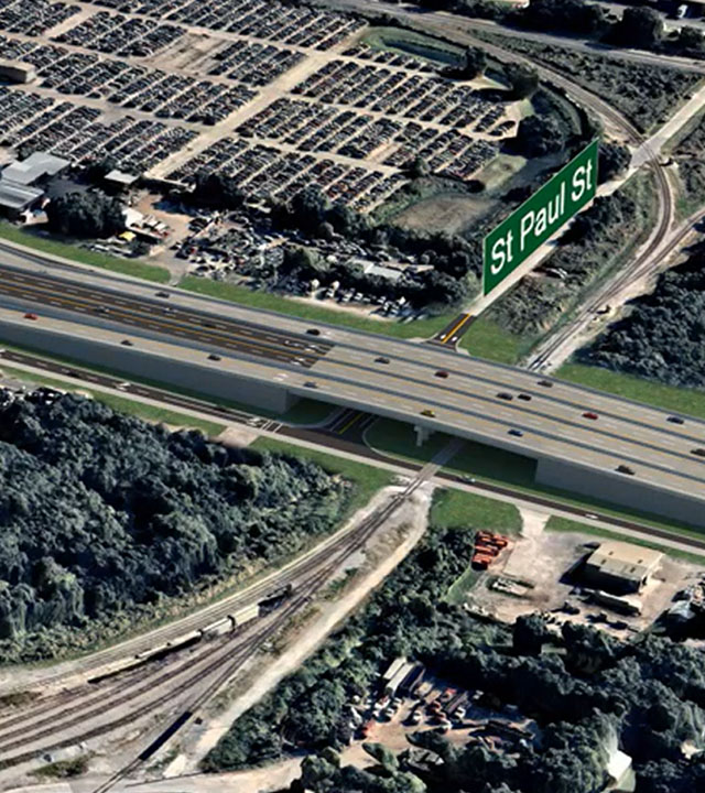 Aerial view of highway overpass, labeled "St Paul St," with surrounding industrial area and railway tracks