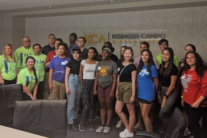 Group of diverse young people in a conference room, with some wearing FLIP t-shirts