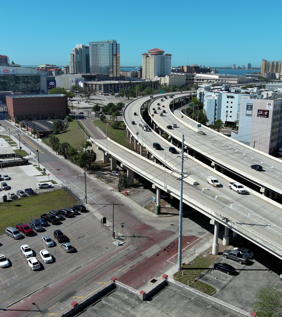 Elevated highway in a city with surrounding buildings and parking lots